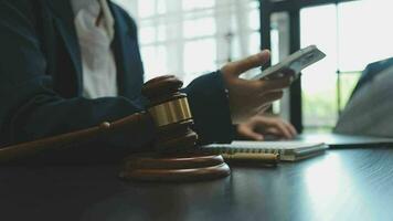 Business and lawyers discussing contract papers with brass scale on desk in office. Law, legal services, advice, justice and law concept picture with film grain effect video