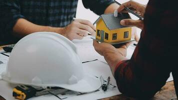 Image of team engineer checks construction blueprints on new project with engineering tools at desk in office. video