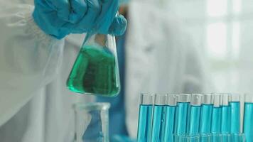 Health care researchers working in life science laboratory. Young female research scientist and senior male supervisor preparing and analyzing microscope slides in research lab. video