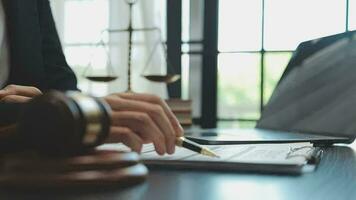 Business and lawyers discussing contract papers with brass scale on desk in office. Law, legal services, advice, justice and law concept picture with film grain effect video