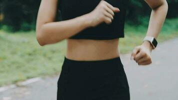 A young woman runner runs at sunset in a park in the park. video