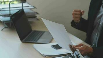 atraente o negócio ásia homem trabalhando com computador computador portátil em de madeira mesa às lar. analisando conectados dados para sucesso o negócio video