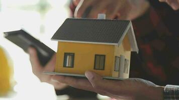 équipe de Multi-éthnique architectes travail sur construction des plans dans réunion chambre. ingénieurs discuter sur projet dans bureau. mature homme d'affaire et femme permanent autour table travail sur plan. video