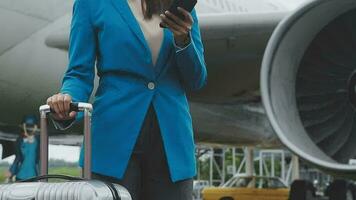 mujer de negocios mano participación tableta mientras que lleva equipaje con aeropuerto antecedentes video