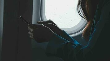 Traveling and technology. Flying at first class. Pretty young businees woman using smartphone while sitting in airplane. video