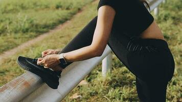 Young fitness woman runner stretching legs before run on city video