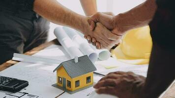 Image of team engineer checks construction blueprints on new project with engineering tools at desk in office. video