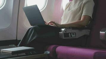 Woman using laptop while is sitting in plane near window. video