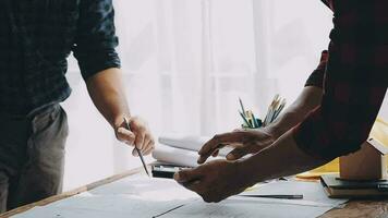 Image of team engineer checks construction blueprints on new project with engineering tools at desk in office. video