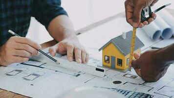 Image of team engineer checks construction blueprints on new project with engineering tools at desk in office. video