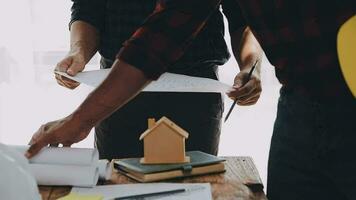 Image of team engineer checks construction blueprints on new project with engineering tools at desk in office. video