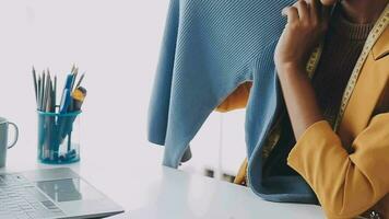 A few finishing touches and itll be ready. Shot of a young fashion designer working on a garment hanging over a mannequin. video