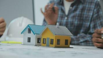 Team of multiethnic architects working on construction plans in meeting room. Engineers discussing on project in office. Mature businessman and woman standing around table working on blueprint. video