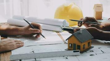 Image of team engineer checks construction blueprints on new project with engineering tools at desk in office. video