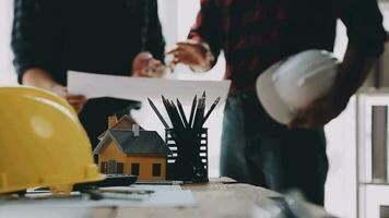 Image of team engineer checks construction blueprints on new project with engineering tools at desk in office. video