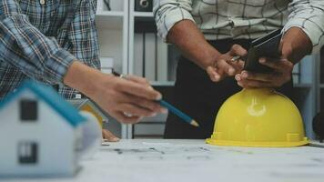 Team of multiethnic architects working on construction plans in meeting room. Engineers discussing on project in office. Mature businessman and woman standing around table working on blueprint. video