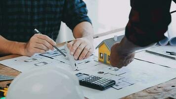 Image of team engineer checks construction blueprints on new project with engineering tools at desk in office. video