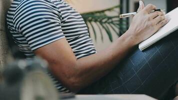 joven hombre de negocios que trabaja en casa con una computadora portátil y papeles en el escritorio video