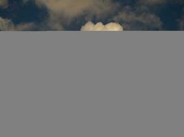 Fluffy clouds over sunset sky. Fluffy cumulus cloud shape photo, gloomy cloudscape background, smoke in the sky photo
