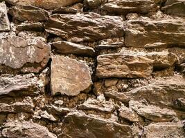 antiguo Roca pared modelo cerca ver fondo, antiguo ladrillos superficie. natural rock pared foto