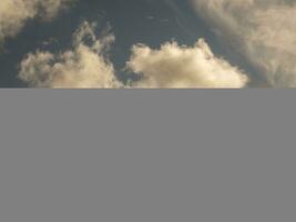 Fluffy clouds over sunset sky. Fluffy cumulus cloud shape photo, gloomy cloudscape background, smoke in the sky photo