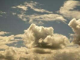 White clouds over sunset summer sky background. Fluffy cumulus clouds shape photo