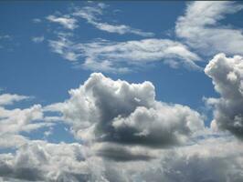 White clouds over sunset summer sky background. Fluffy cumulus clouds shape photo