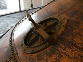 Metallic manhole cover and an industrial construction close view photo