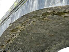 antiguo Roca puente en Irlanda, antiguo puente hecho de piedras y ladrillos foto