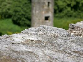 Old stone over ancient tower background, Blarney castle in Ireland, old ancient celtic fortress photo