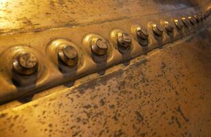 Metal background, old copper wall with rivets photo