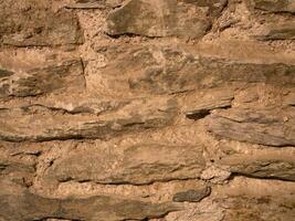 Old stone wall pattern close view background, ancient bricks surface photo