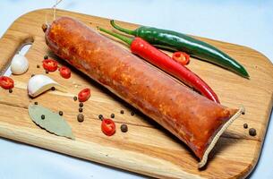 Tasty sausages and vegetables isolated over solid background photo