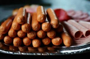 Tasty sausages and vegetables isolated over solid background photo