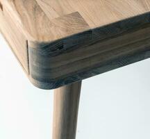Wooden table corner and leg close view photo, wooden eco furniture elements background. Solid wood furniture leg photo