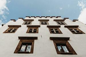 Facade of an ancient building with old windows and blue sky on the background photo