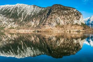 enorme montaña con nieve parte superior en el frontera de el lago foto