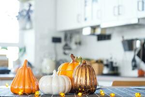 Decor of the white classic kitchen with pumpkins for Halloween and harvest. Autumn mood in the home interior, modern loft style. photo