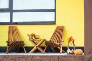 Autumn decor on the porch of the house outside in the yard of pumpkin, lantern, garlands, hats, jack lantern. Halloween party, autumn mood, Harvest festival photo