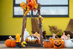 Autumn decor on the porch of the house outside in the yard of pumpkin, lantern, garlands, hats, jack lantern. Halloween party, autumn mood, Harvest festival photo