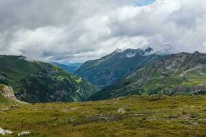 Mountains chain in Austrian Alps under white clouds photo