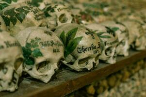 Hallstatt, Austria - 2 Apr 2018 - Skulls of dead citizens of Hallstatt painted with their names and various ornaments photo