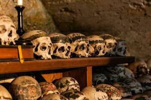 Hallstatt, Austria - 2 Apr 2018 - Skulls of dead citizens of Hallstatt painted with their names and various ornaments photo