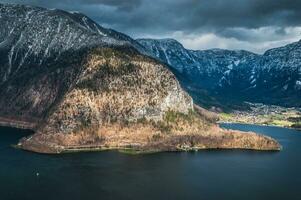 Austrian Alps covered with snow with a beautiful calm lake and cloudy sky on the background photo