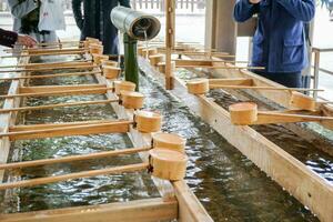 Holy well and wooden scoop or dipper photo