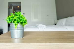 Wooden table with vintage vase plastic plant on bedroom photo