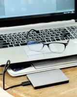 Notebook grey modern black keyboard with hdd grey and spectacles photo