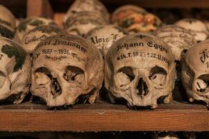 Hallstatt, Austria - 2 Apr 2018 - Skulls of dead citizens of Hallstatt painted with their names and various ornaments photo