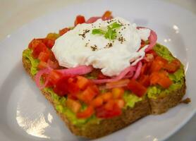 Smashed avocado toast with eggs photo