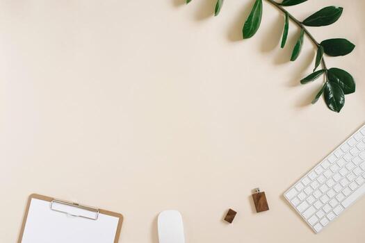 Modern desktop of a freelancer or blogger with a keyboard, mouse, pen, usb drive and Notepad with a blank sheet of paper on a light beige background with space copying. Flat lay photo
